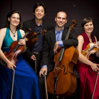 Jupiter String Quartet dressed formally, with their instruments