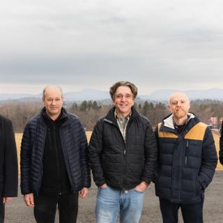 J. Robinson, E. Sawyer, R. Bashford, J. Baum and Brian House standing outdoors in coats; behind them is the Holyoke Range