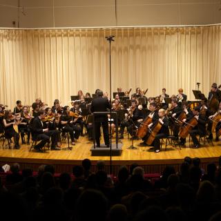 The Amherst Symphony orchestra on the Buckley Recital Hall stage in front of an audience