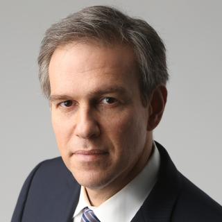 Headshot of Bret Stephens, who is looking at the camera and wearing a formal suit