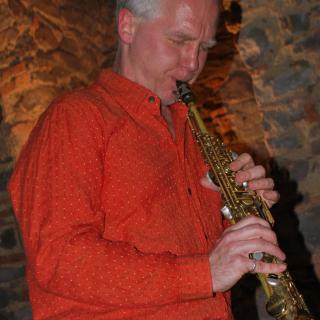 Carl Clements, standing and playing a saxophone