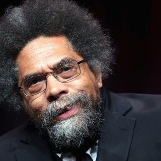 Photo of Dr. Cornel West with arm raised