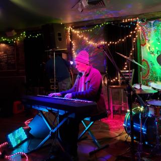 Eric Sawyer playing keyboard amid multicolored lights