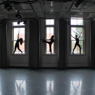 Five dancers posing in the windows of a studio