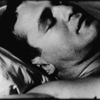 Black-and-white closeup of a sleeping man's face