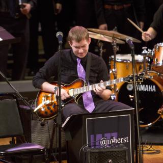 Rob Croll '16 playing jazz guitar on stage with the ACJE 