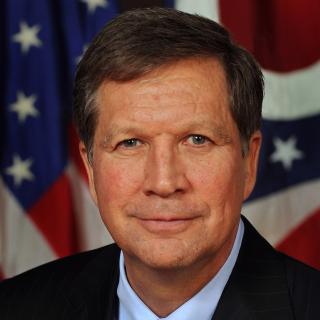 Closeup photo of John Kasich with U.S. and Ohio state flags in background