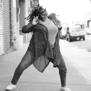 Black-and-white photo of Kayla Hamilton dancing on a city street