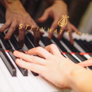 Hands on a Steinway & Sons piano keyboard