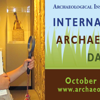 Young boy in the Mead Art Museum, holding a magnifying glass and a notebook whose cover says "FIELD NOTES", along with International Archaeology logo, www.archaeologyday.org