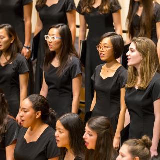 Young women dressed in black, singing on the Buckley Recital Hall stage