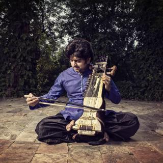 Suhail Yusuf Khan seated, playing the sarangi