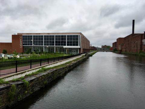The Massachusetts Green High-Performance Computing Center in Holyoke, a brick and glass building situated alongside a canal.