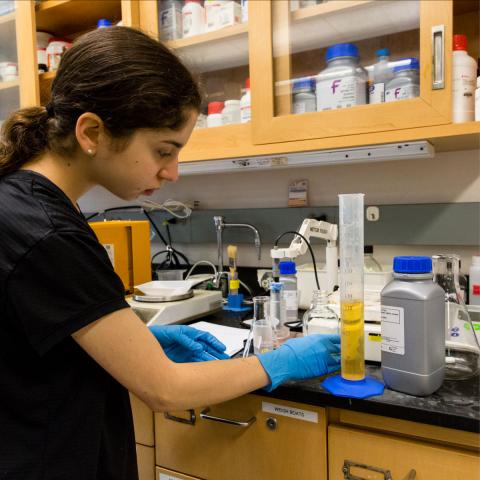 Student in lab measures a liquid