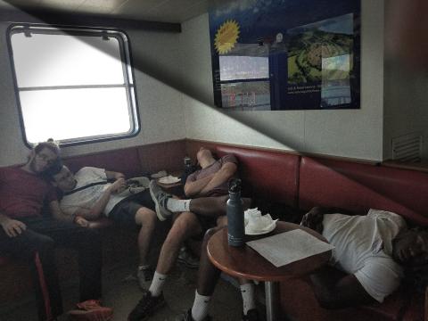 Four students asleep on a coach