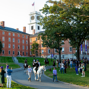 Biddy Martin riding a horse through the Amherst College quad