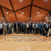 A group of men on a basketball court with the words Hixon's Court written on the floor