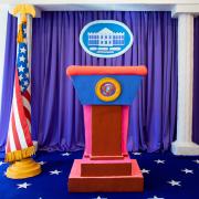 A miniature clay sculpture of the White House podium next to an American flag