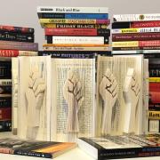 Books with a raised fist sculpted into the fore edge