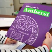 A staff members holds a Welcome to Amherst publication