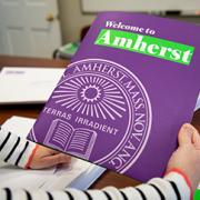 A photo of a person's hands holding an Amherst College brochure