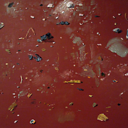 Linen painted red with paint splotches of various colors scattered like rubble across the surface