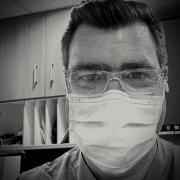 A black and white photo of a man in a medical mask