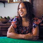 A Black woman sitting at a table smiling